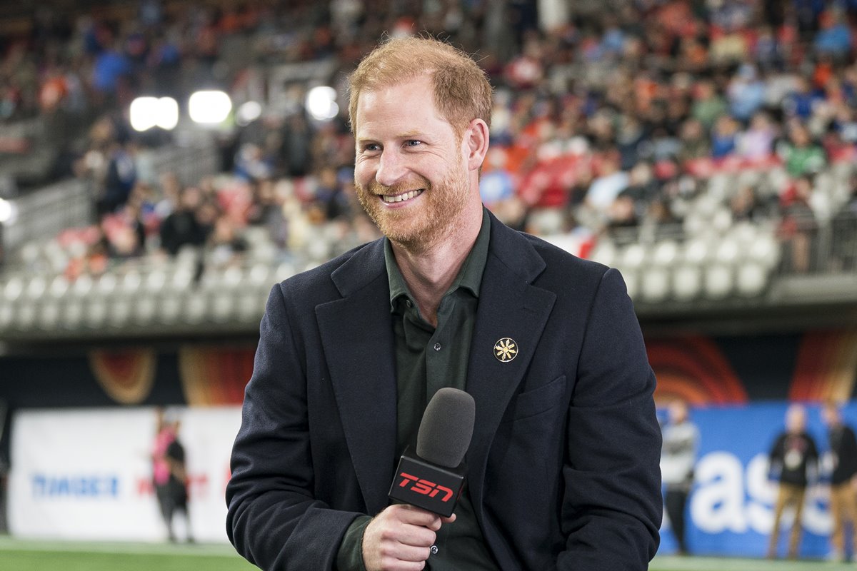 Meghan Markle estaria relutante em dar o divórcio ao príncipe Harry 45 Foto colorida de homem segurando microfone e em estádio de futebol - Metrópoles