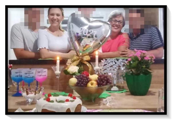 Suspeita aparece sorridente ao lado dos sogros com um bolo